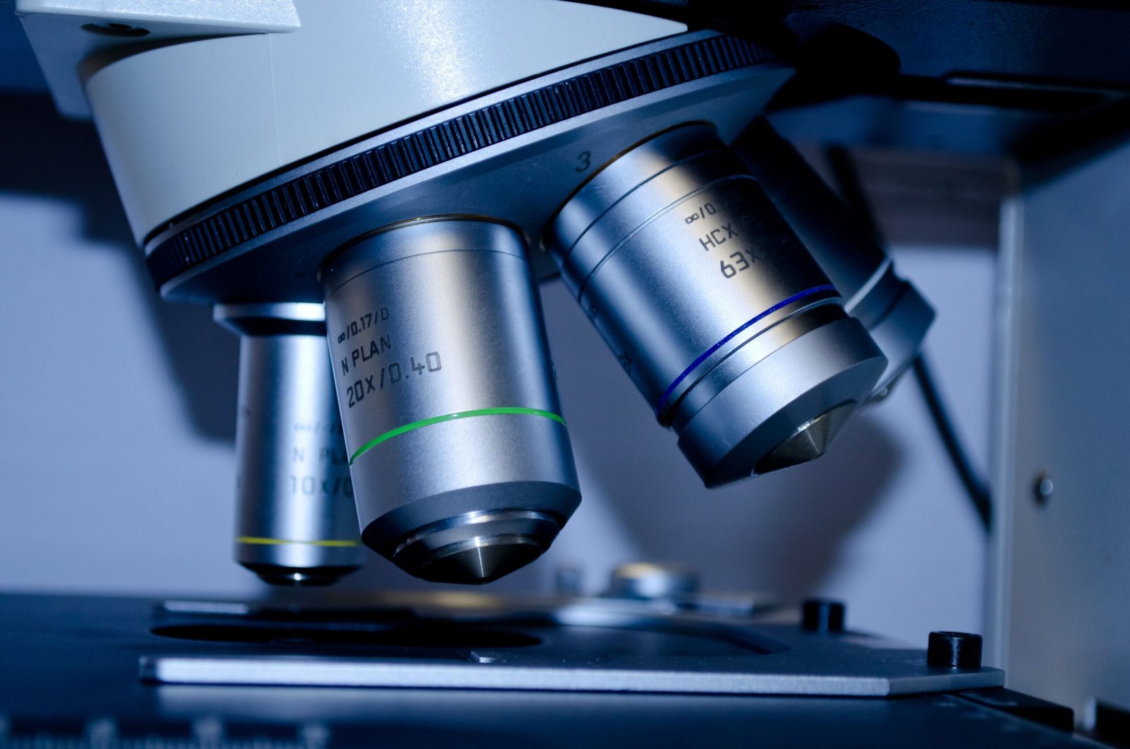 Detailed view of optical microscope lenses in a laboratory setting.